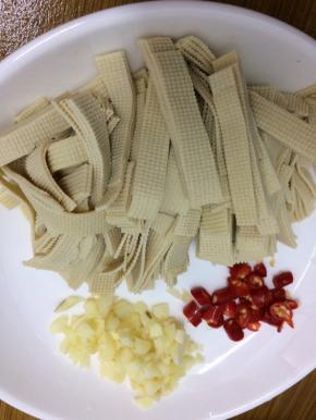 将干豆腐切成小条姜、蒜、小米椒切成小粒