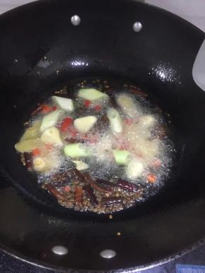 
锅内加油烧热以后，倒入辣椒段花椒粒，炒出香味以后加入姜片、葱段、小米辣，加入牛腩翻炒几下，依次加入白糖一勺、料酒和生抽。待白糖融化炒制变色以后，加入四川印象麻辣牛油火锅底料。