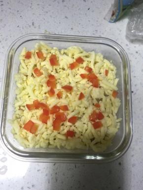 面上撒上芝士和红椒粒，180度上下火中层烤12-15分钟，待芝士完全化开表面微黄即可