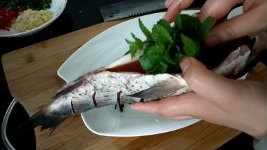 腌好的鱼洗干净用厨房纸擦干，鱼腹中放一把葱段和姜丝，临时添加一小把薄荷（忽略）