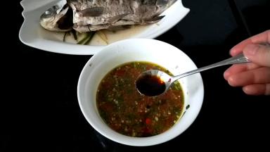 将蒸好鱼的汤汁倒入调味碗中（介意的可不要），加入蒸鱼鼓油和红油拌匀