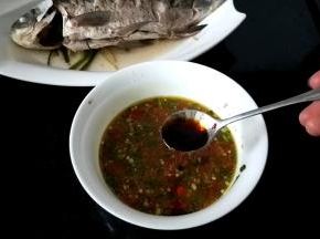 将蒸好鱼的汤汁倒入调味碗中（介意的可不要），加入蒸鱼鼓油和红油拌匀