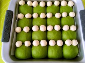 抹茶面团二次发酵好后，取出，烤箱预热180度，将白色面团搓圆球，装饰成青蛙的眼睛