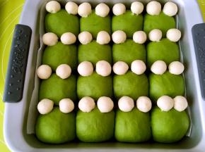 抹茶面团二次发酵好后，取出，烤箱预热180度，将白色面团搓圆球，装饰成青蛙的眼睛