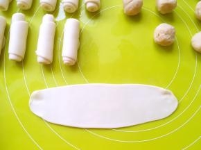 将松弛好的面团擀成长条，再卷成牛舌卷，继续松弛15分钟