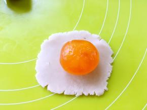 将红豆酥分成10等份，红豆沙压扁，包裹蛋黄