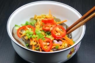 把切好辣椒、胡萝卜丝放入手撕茄子上，趁热倒入手撕茄子上，拌均即可；