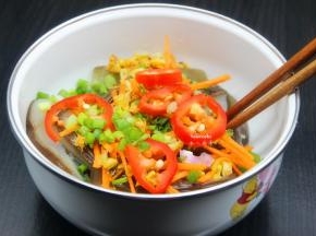 把切好辣椒、胡萝卜丝放入手撕茄子上，趁热倒入手撕茄子上，拌均即可；