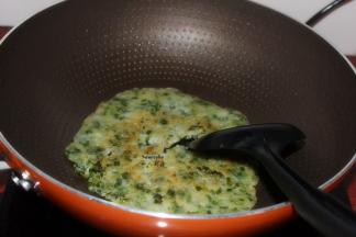 煎好的韭菜煎饼，用锅铲切成块即可。PS：也可用刀切块。