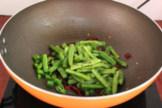 加入炸熟的四季豆翻炒；