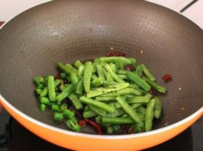 加入炸熟的四季豆翻炒；