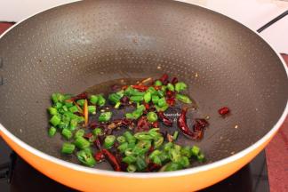 锅中留少许油，放入干辣椒、青辣椒爆炒；