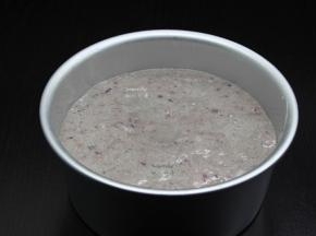 盆内壁摸上油，把面糊倒入，轻轻磕碰几下，减少气孔；