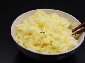 把米饭加入蛋黄中拌均，粒粒分明，均匀裹上蛋黄液；