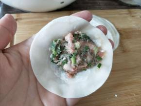 饺子皮摊手掌中，放入肉馅