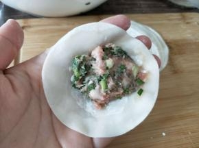 饺子皮摊手掌中，放入肉馅