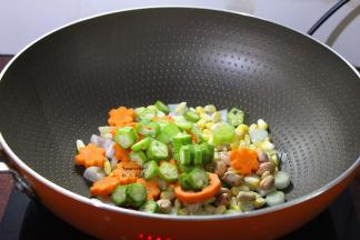 接着放秋葵、胡萝卜、玉米、花生大火翻炒八成熟；