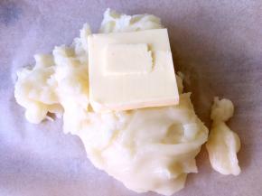 取一块油纸，将蒸好的麻薯倒在油纸上，加入黄油，麻薯的热度会热化黄油的，戴一次性手套揉均匀，让麻薯充分与黄油融合