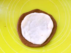 从冰箱取出麻薯，分成三等份，取一份擀成比可可面团小一点的圆片，铺在可可面团内