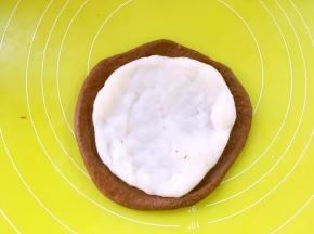 从冰箱取出麻薯，分成三等份，取一份擀成比可可面团小一点的圆片，铺在可可面团内