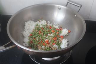 倒入米饭和豆角肉沫下去一起翻炒。大概炒一分钟，因为饭是刚煮的。所以饭是很松散的