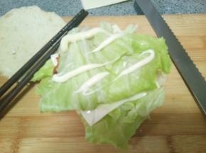 再盖上一片生菜叶，挤上沙拉酱