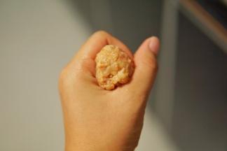 之前搅拌好的猪肉馅，借助手的虎口做成圆形