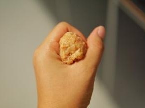 之前搅拌好的猪肉馅，借助手的虎口做成圆形
