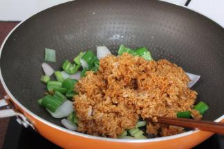 把拌均的酱饭倒入锅中翻炒；PS：不断翻炒，防止粘；