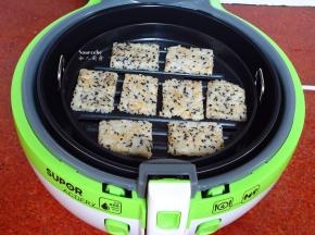 炸篮抹一层油，撕开保鲜膜，把米饭饼胚放入；