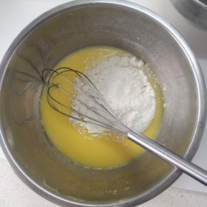 将过筛好的低粉倒入蛋黄糊中，用手抽搅拌，搅拌至蛋黄糊细腻，无颗粒。