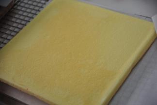 等表面热气散去，即可另取一张油纸，将蛋糕反过来，揭开油纸，继续盖上蛋糕上。
注：若是表现热气没散去就翻面，容易造成表皮的损坏，朋友们自己做时自己体会。