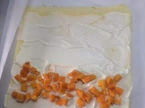 取出200克左右的淡奶油，配以10%的砂糖打发至抹面状态，在蛋糕上抹上奶油，放上准备好的水果，我是放的芒果，最边缘的位置不用抹奶油。