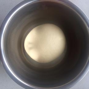 面团滚圆放入盆中加盖保鲜膜，放在温暖的环境下发酵