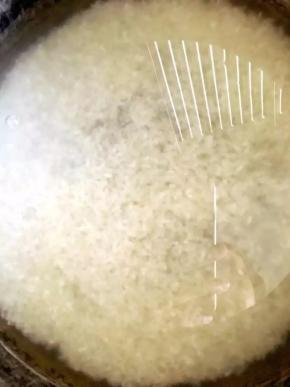 6、	倒入锅中，加入高于大米一指的水，开启煮饭功能