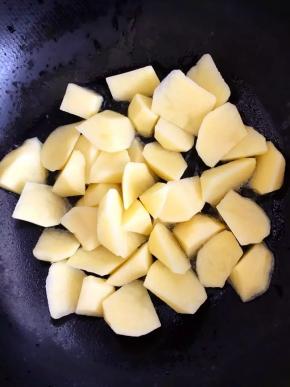 4、锅中放油烧至温热时倒入土豆块，中小火慢煎