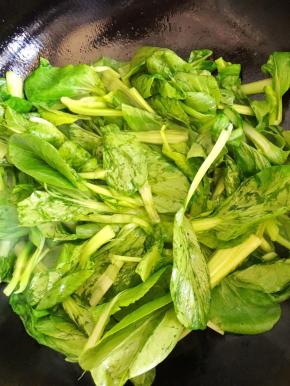 3、倒入油菜快速翻炒变软