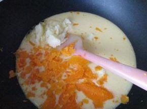 把拌好的糊倒入不粘锅中，放入黄油和压碎的咸蛋黄搅拌均匀