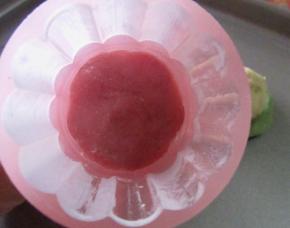 用月饼模具，选立体的樱花片，模具中撒一点熟的糯米粉防粘。先取一小块红色面团，压在花片上，把花形部分填满