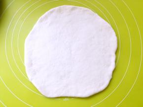 发酵好的面团手指沾点干粉，按下去会有个圆圆的洞，不会弹，将发酵好的面团取出排气，揉均匀，擀成比模具大一点的圆片