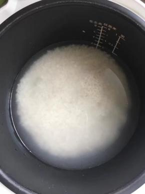 2、	倒入锅中，加入高于大米两指的水，开启煮饭功能