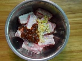 排骨中加入盐、酱油、蒜末、姜末、葱末和烤肉酱拌匀