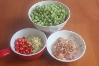 瘦肉用刀切成肉沫，豆角洗净切小粒儿，小米辣切小丁，姜蒜切粒，肉沫用胡椒粉和生抽腌制20分钟