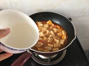 火开大一些，沿着锅边均匀的倒下勾兑的淀粉水