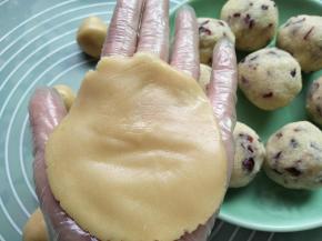 取一个饼皮按扁，记得戴手套操作