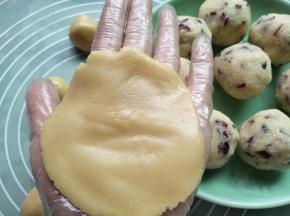 取一个饼皮按扁，记得戴手套操作