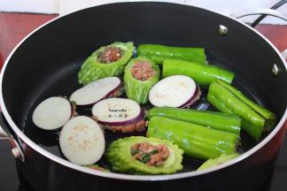 热锅，倒油，放入 酿好的茄子、苦瓜、青椒小火煎至黄色