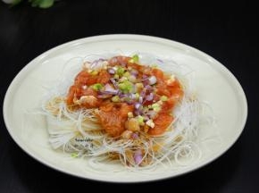 粉丝捞出，沥干水，放入盆子中，上面放入腌制好的猪肉片、葱白、生姜末；淋上橄榄油、芝麻油、盐、酱油；