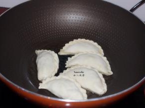 热锅倒油，把韭菜盒子放入锅中，中小火煎至微黄；