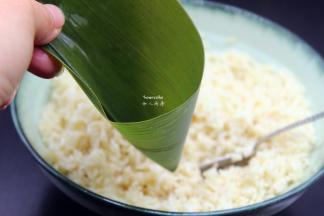 洗净干净的粽叶折叠成漏斗形状，但不能漏；